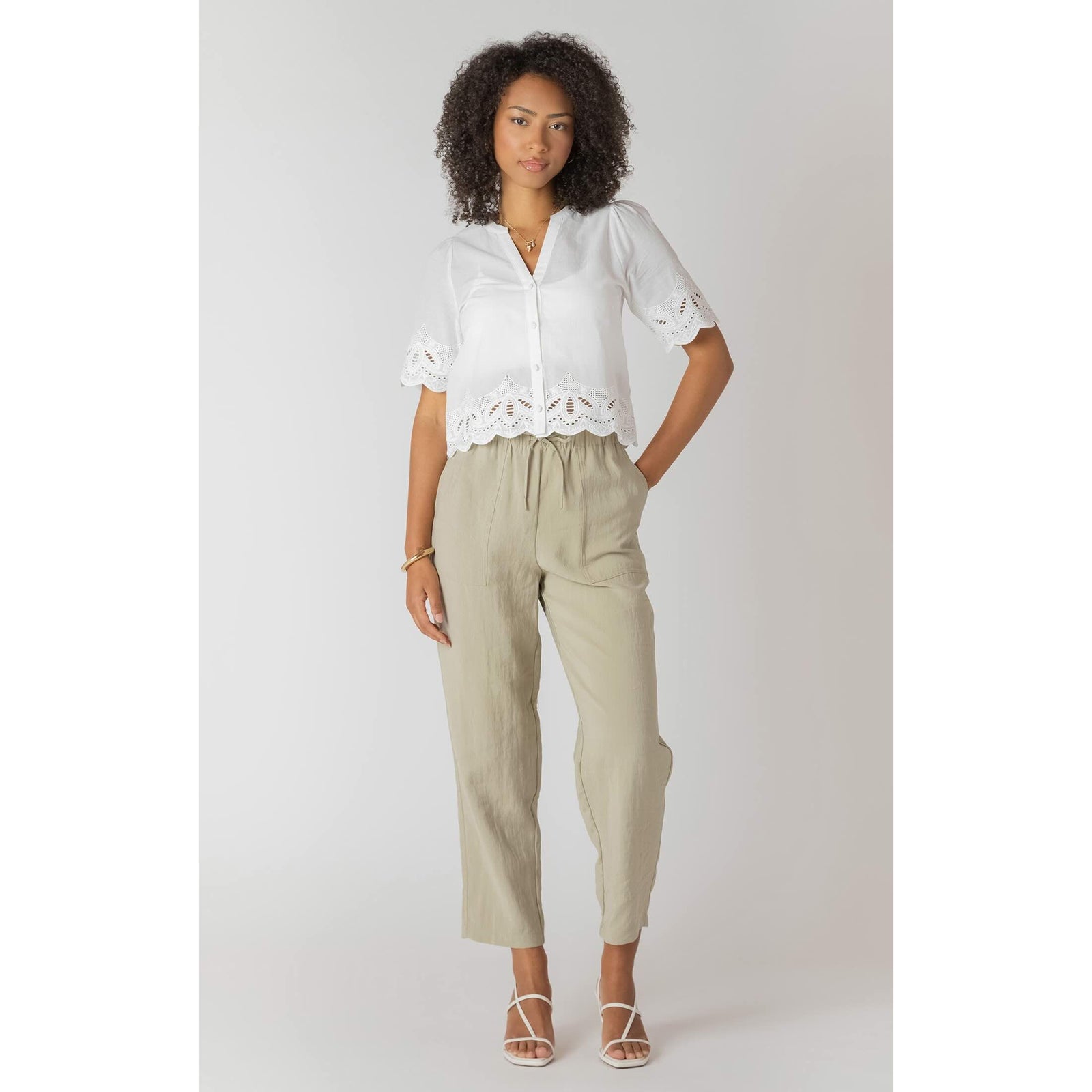Room 34 Eyelet Trim Blouse in white with lace hem and sleeve trim, paired with beige drawstring pants.