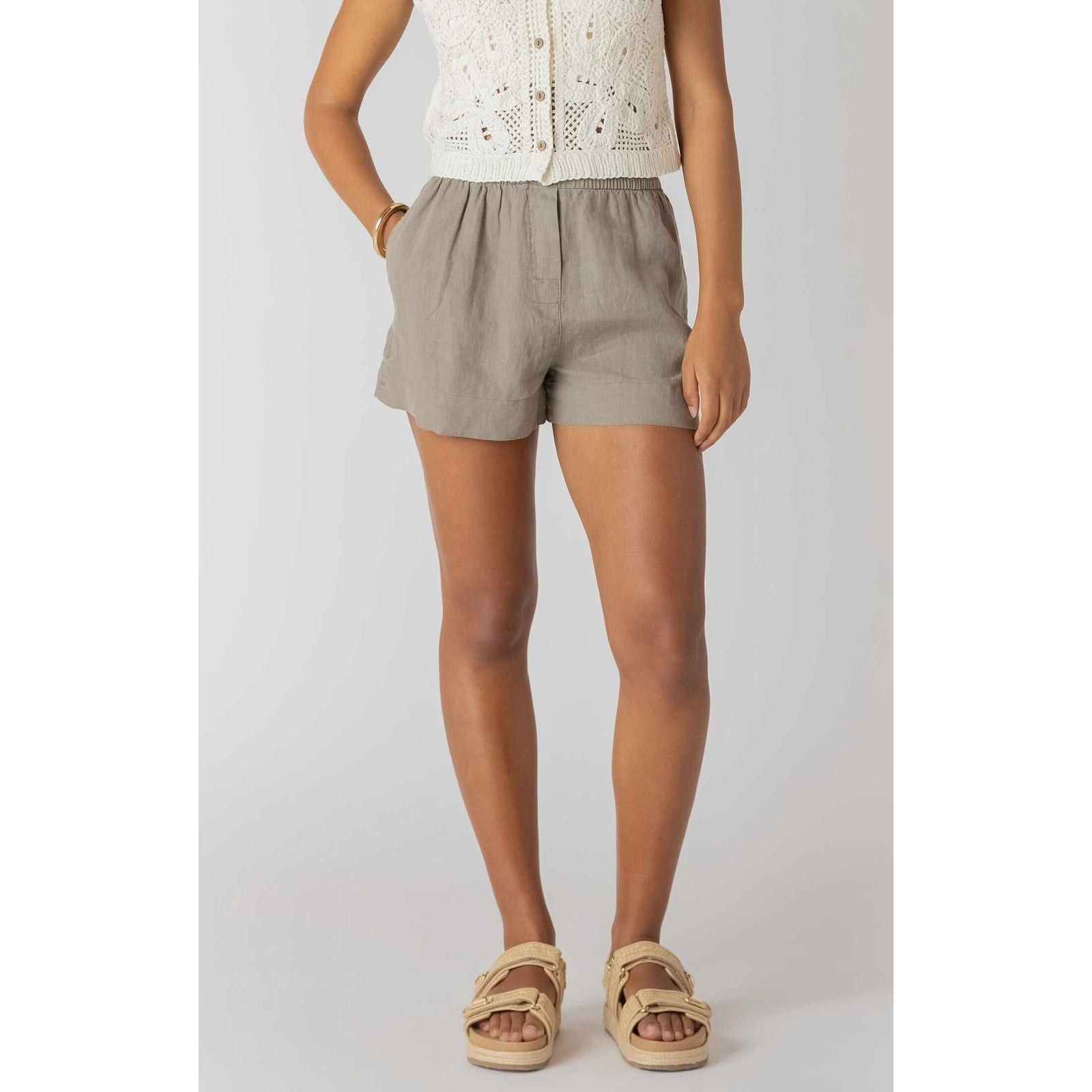 Room 34 Mid-Rise Shorts in taupe on a model, relaxed mid-rise silhouette with an elastic waistband.