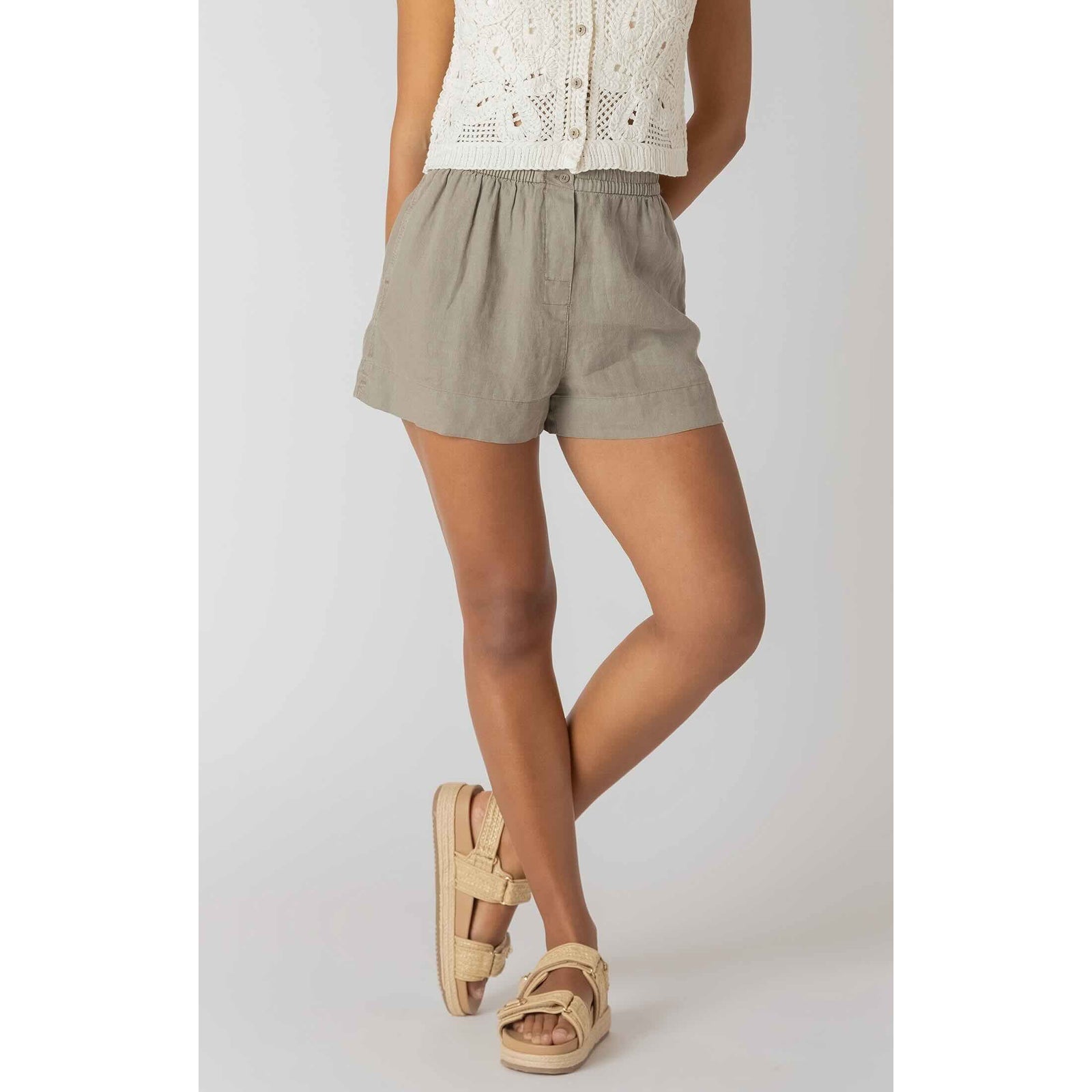 Room 34 Mid-rise Shorts in taupe woven fabric with a relaxed mid-rise silhouette, styled with sandals.