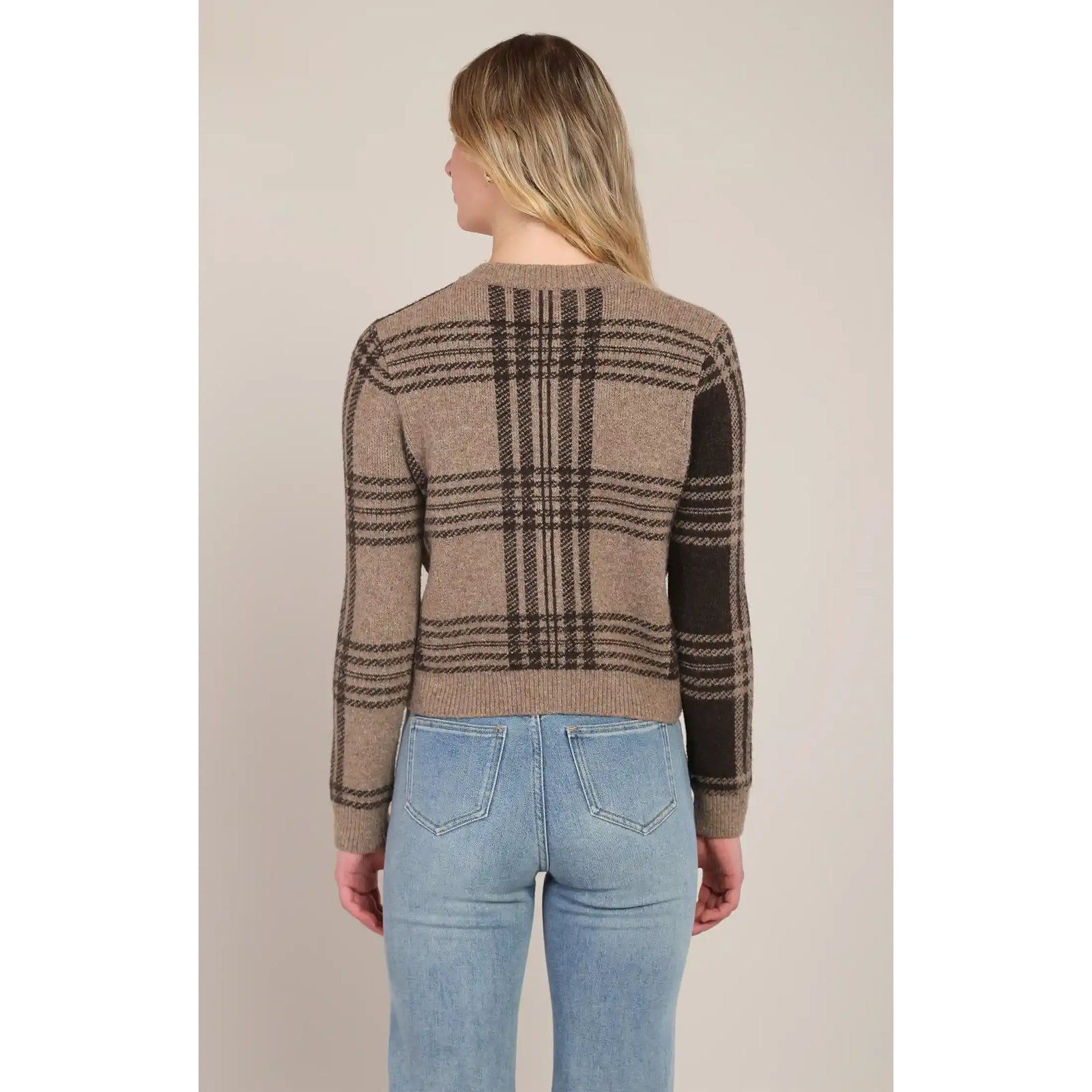 Back view of a taupe-brown plaid cardigan featuring a stretch knit pattern and medium-length fit paired with blue jeans.