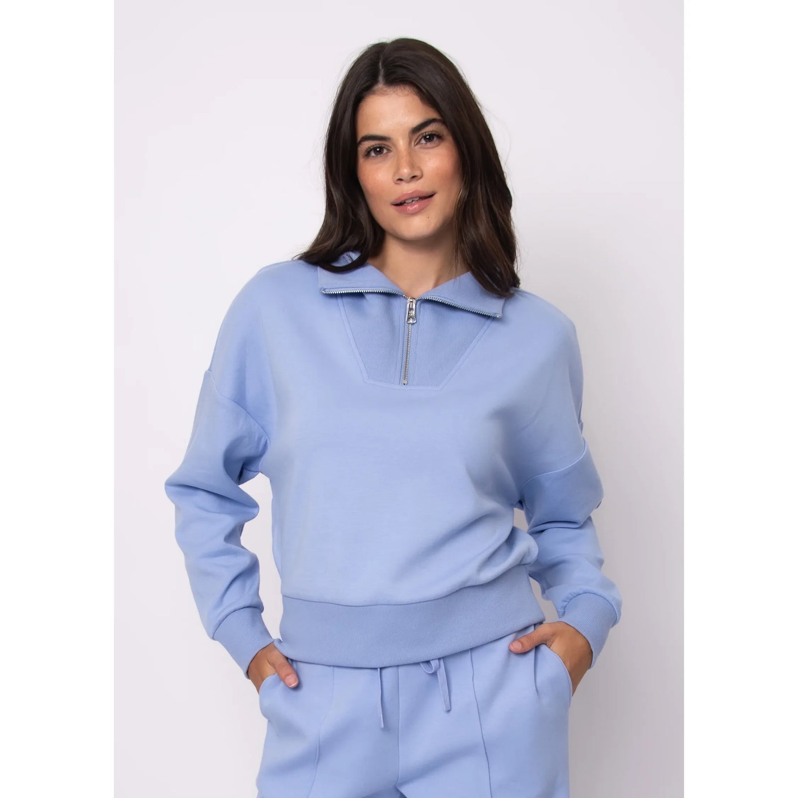Seanni Soft Knit Half Zip Pullover in light blue worn by a model with matching joggers, showcasing a zip collar.
