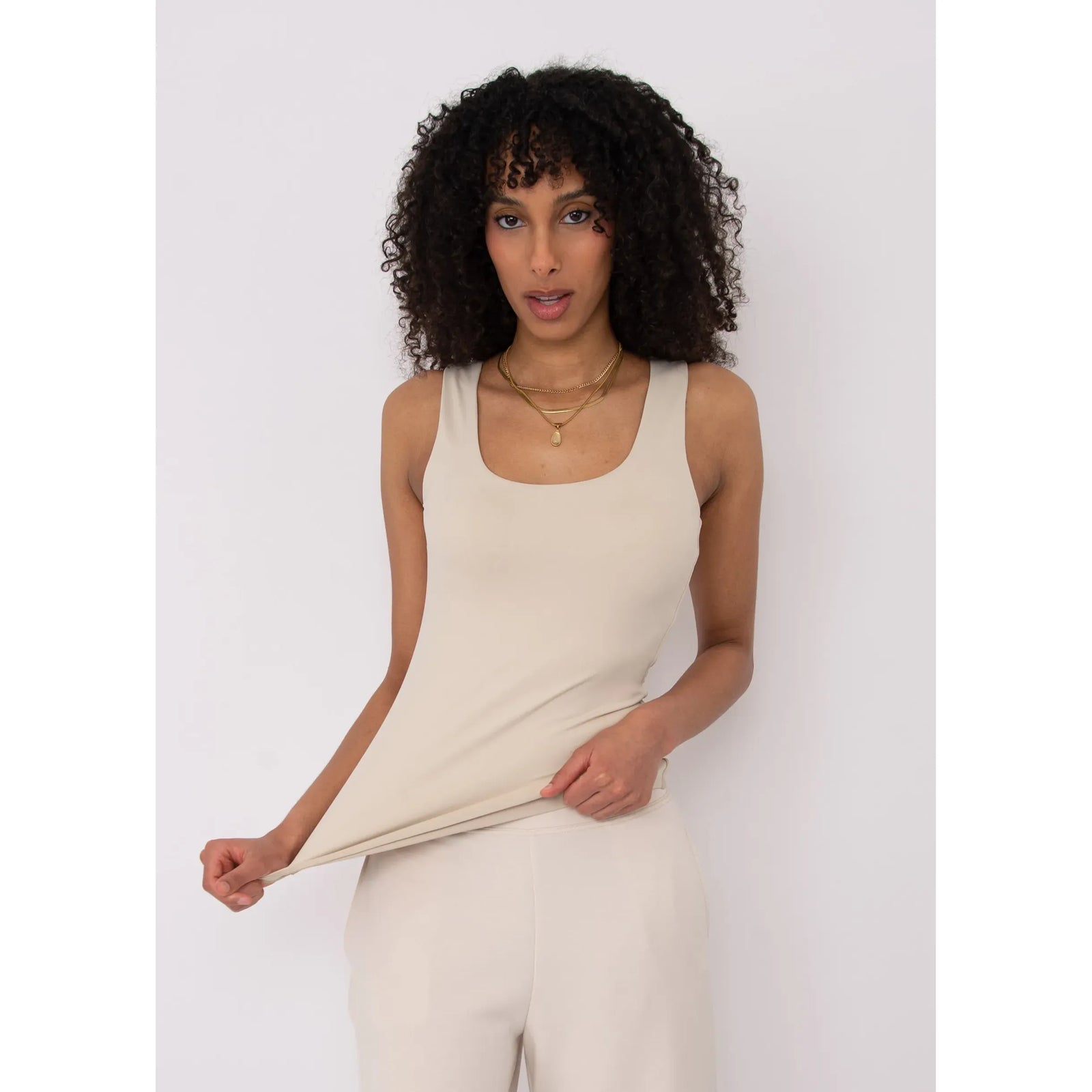 Beige Second Skin Tanith Double Uneck Tank Top worn by model with gold layered necklaces.