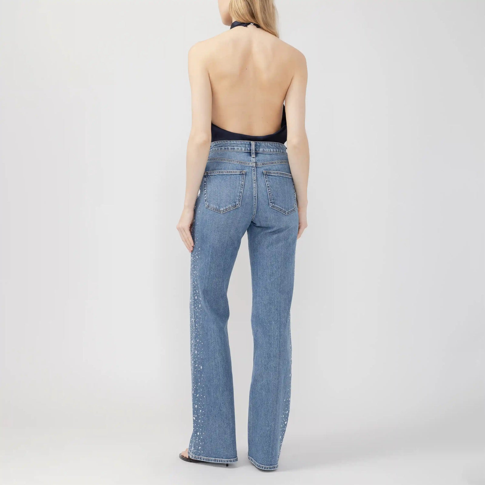 Back view of silver Avery Wildcard trousers featuring a high rise, contoured waistband, and sparkling details along the wide leg.
