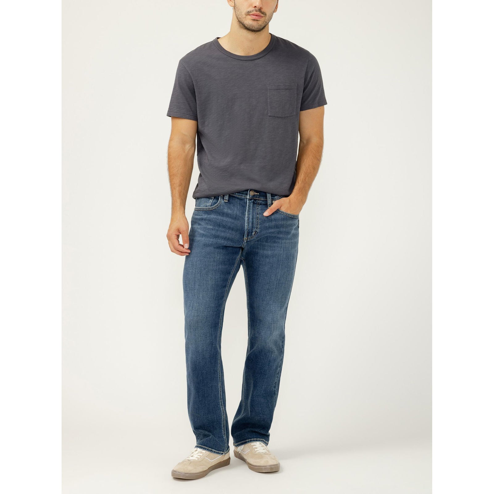 Male model in dark gray tee wearing Silver Jace Slim Bootcut jeans in Tate wash.