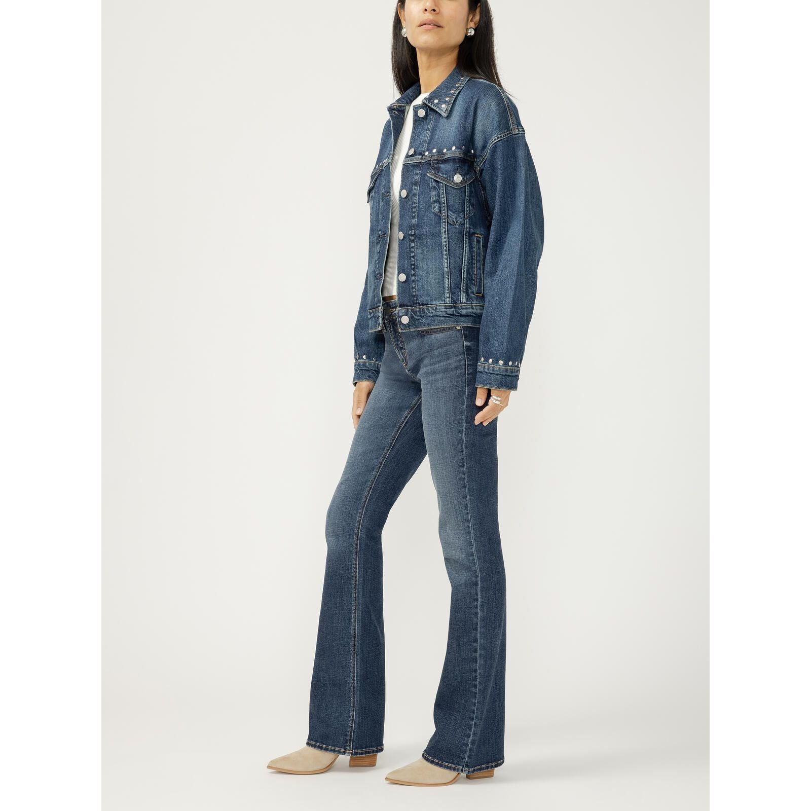 Model wearing a silver-studded 90's denim jacket with metallic studs, a structured yet draped fit.