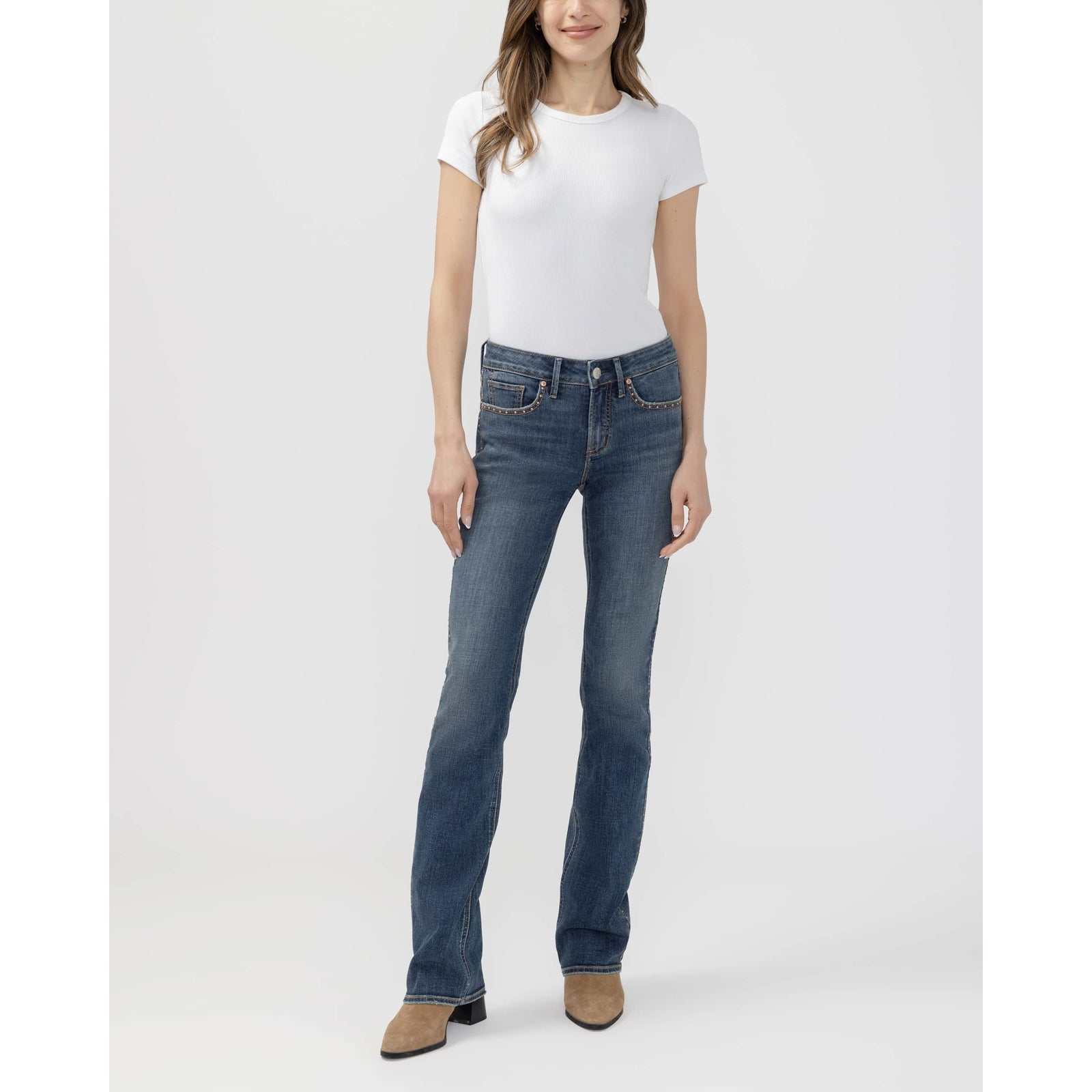 Model in a white tee and blue jeans showcases Suki Slim Boot in Seraphina, tan suede ankle boot.