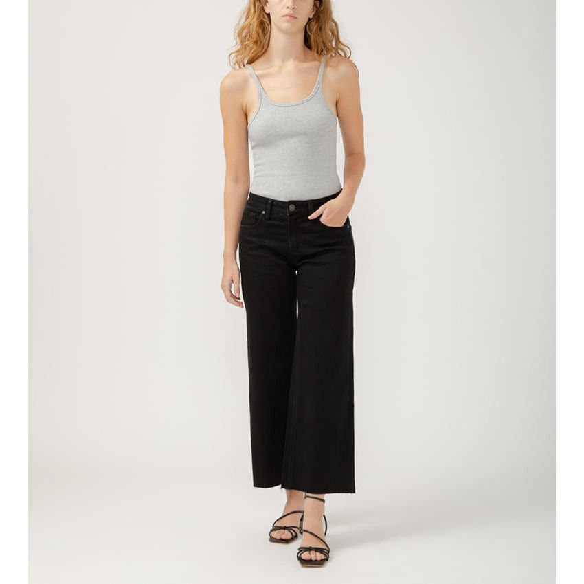 Stylish woman wearing Silver Suki Ankle Wide Leg Black jeans, showcasing a chic mid-rise and wide-leg design.