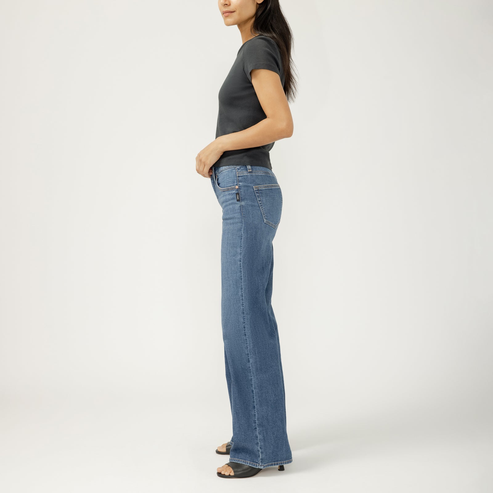 Side view of a model wearing Silver Suki Wide Leg in Broydon jeans with a contoured waistband in dark indigo.