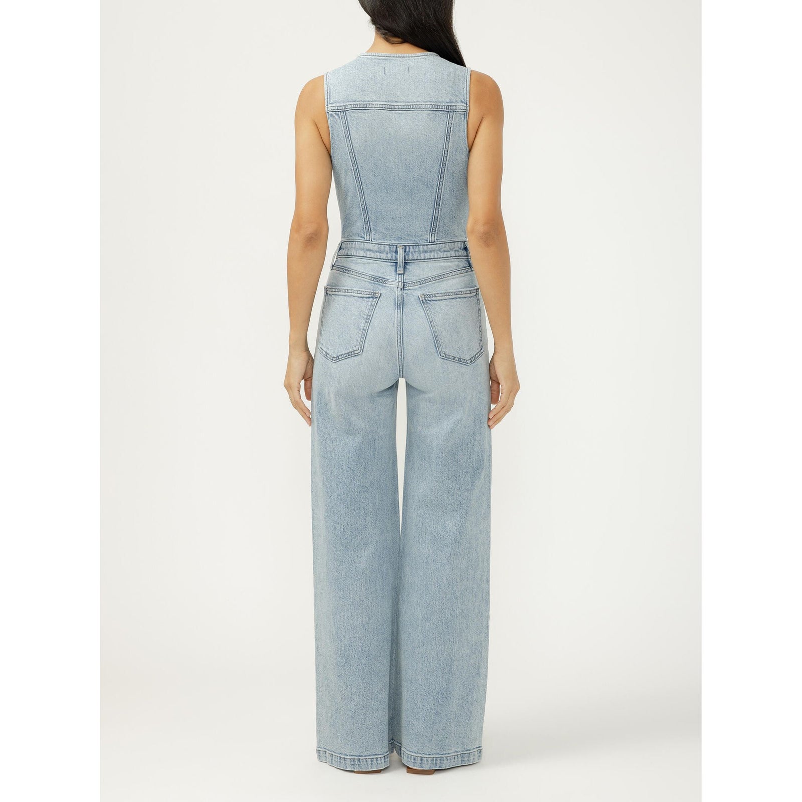 Back view of a silver wide-leg vest jumpsuit in Holbox, light denim with back pockets and seamed panels.