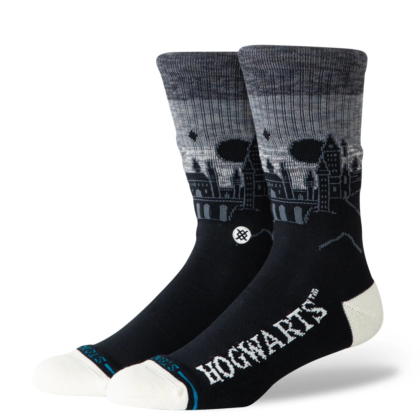 Black crew socks featuring a silhouette of Hogwarts Castle towers against a grey night sky, with HOGWARTS text on the foot and white toe accents.