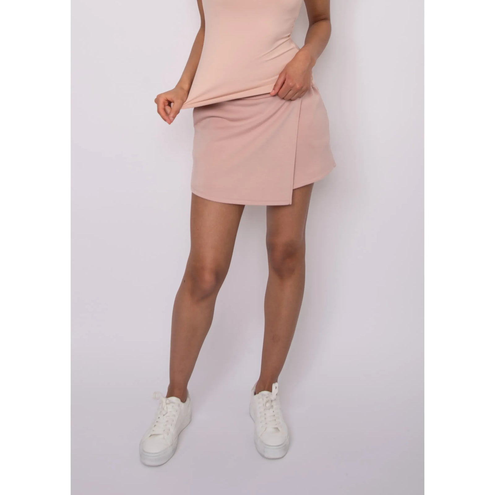 Starry Soft Knit Skort in pale pink knit, relaxed fit; model wearing white sneakers.