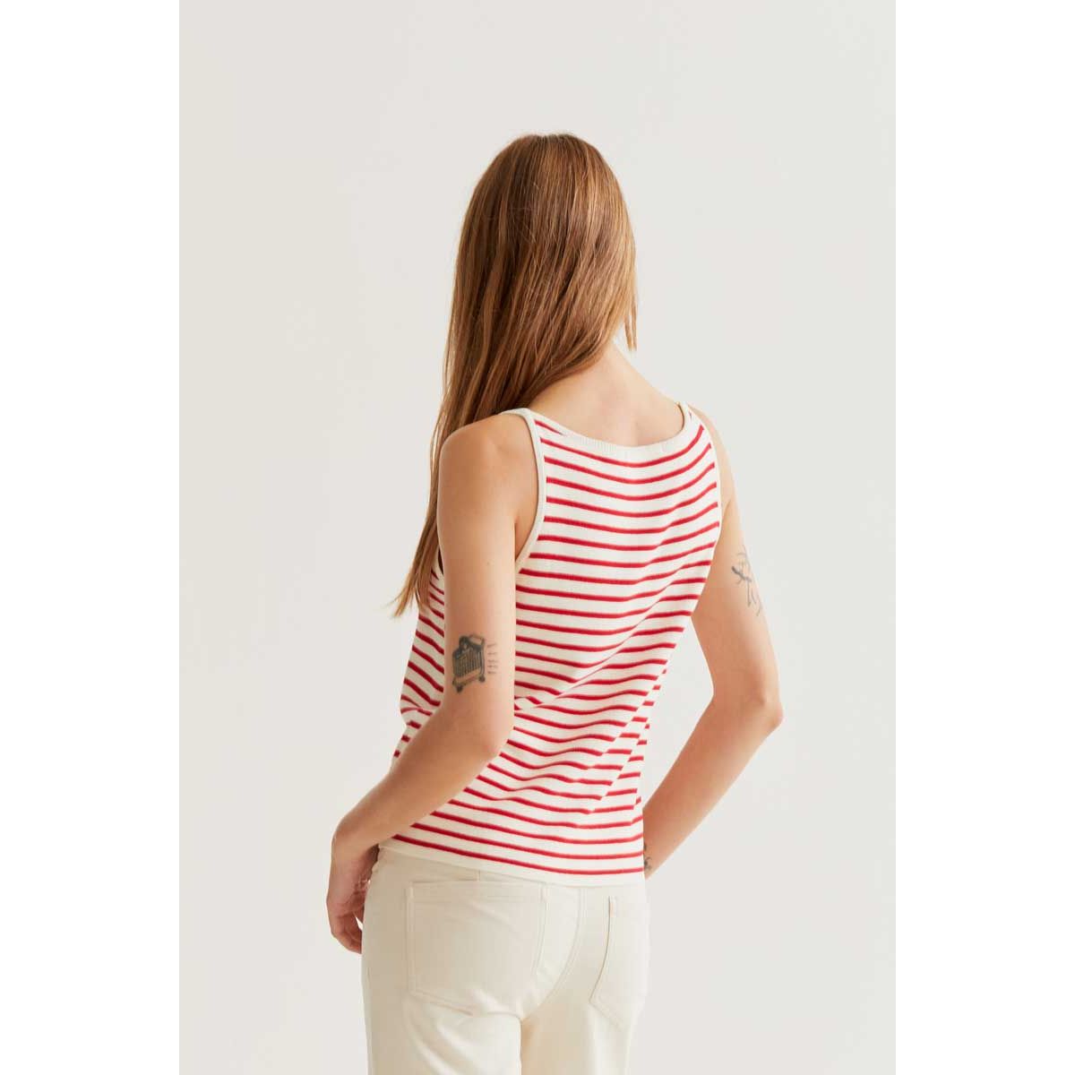Model wearing Strawberry on Red Stripes Tank, a red-and-white striped sleeveless top, back view.