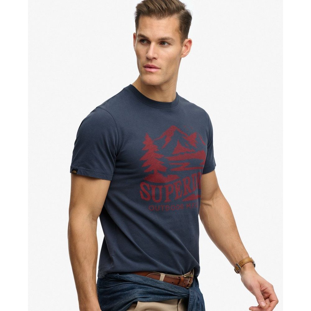 Male model in navy Superdrydry Retro Outdoor Relaxed Tee with red mountain graphic.