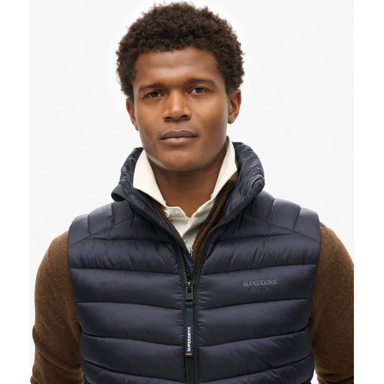 Man in navy Superdry Fuji Sport Padded Gilet with lightweight padding, zip pockets, slim fit.