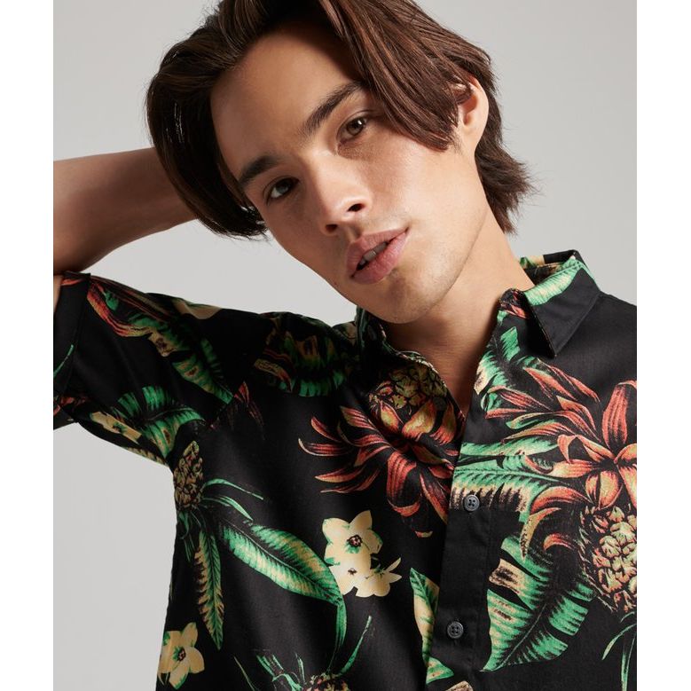 Model wearing Superdry Vintage Hawaiian S/S Shirt with tropical floral print on black, relaxed short-sleeve fit.