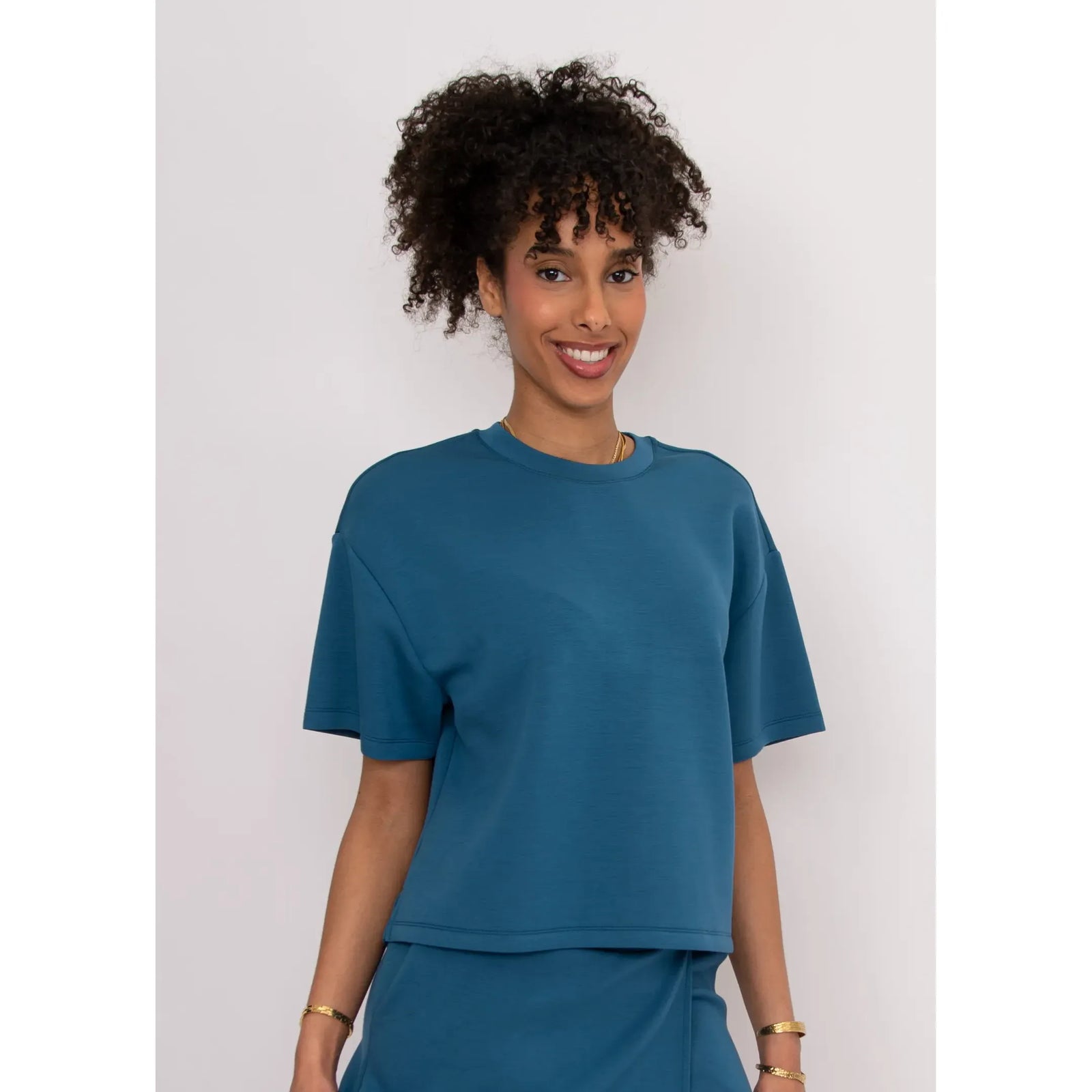 Tess Soft Knit Top in teal, boxy relaxed fit with short sleeves, worn by a model in size Small.