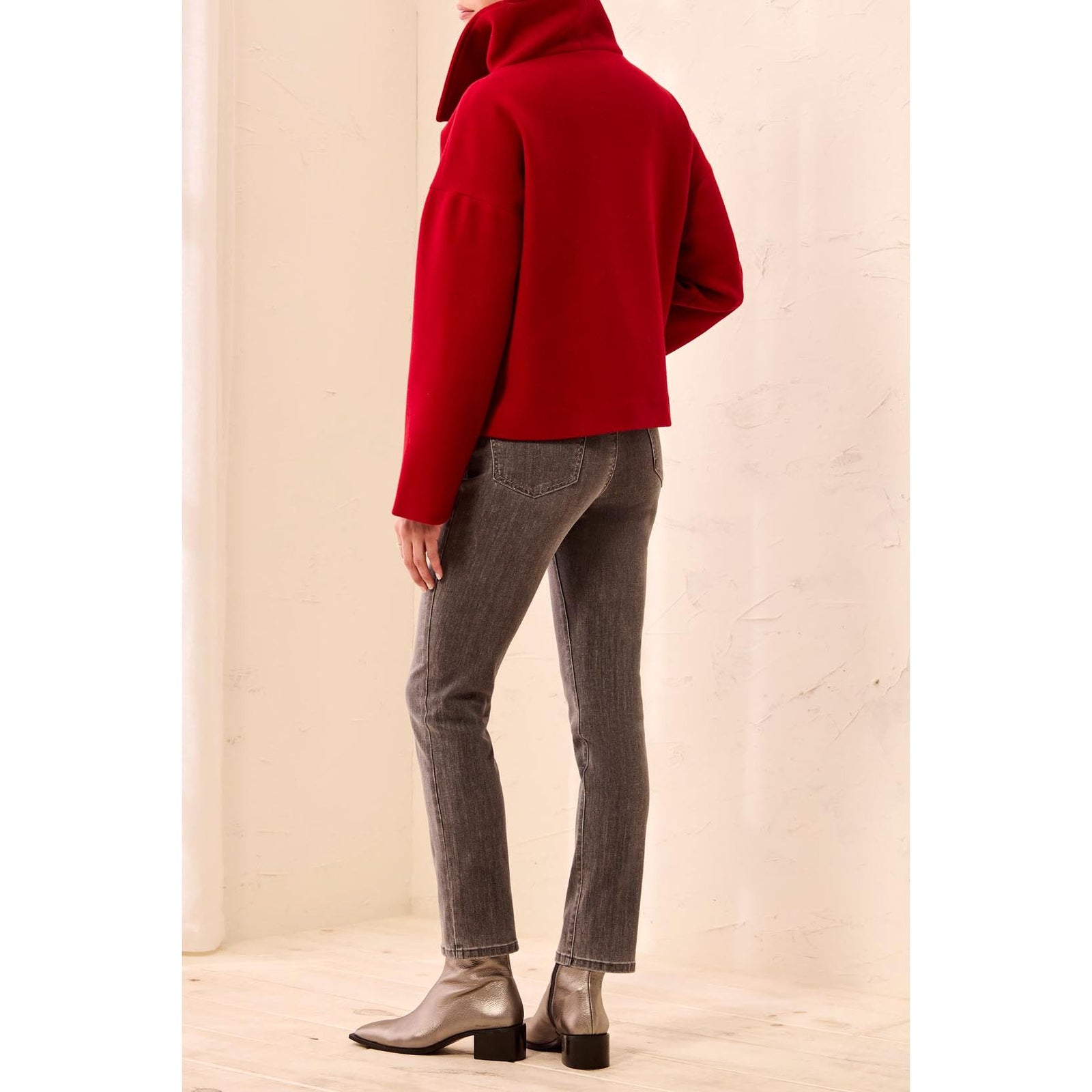 Back view of a model wearing a red Tribal Lofty Funnel Neck Jacket with a relaxed fit and button front.