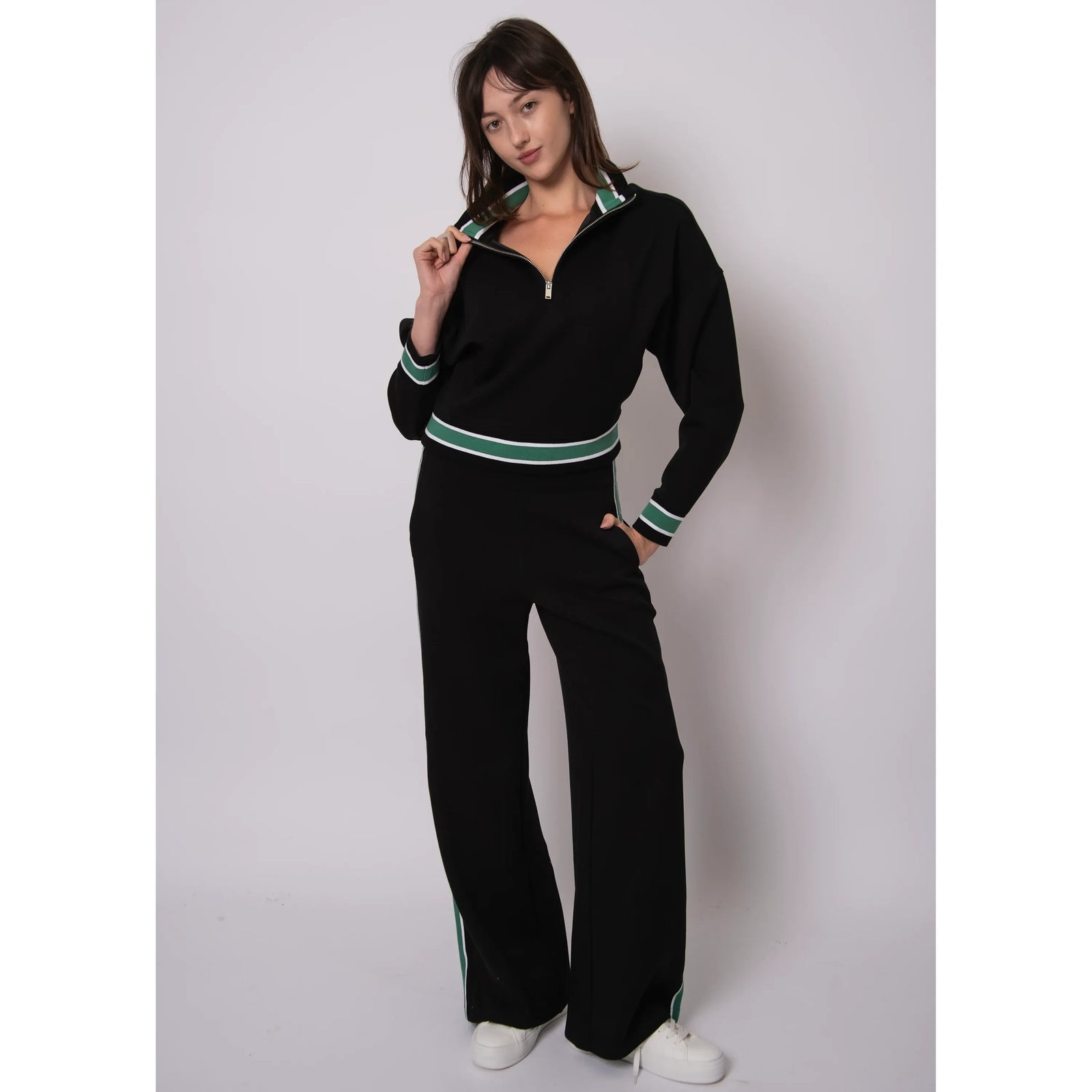 Model wearing Valencia Soft Knit Pull-On Jogger Pants in black with green and white side stripes.