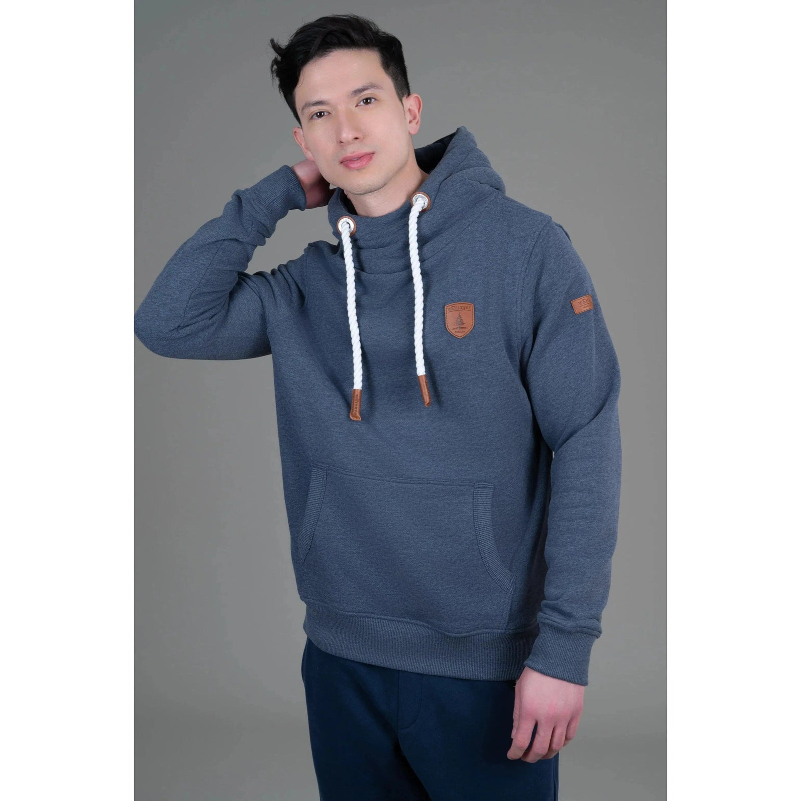 Wanakome Cascade Hoodie in navy worn by Khaleel (6 ft, size Large) with white rope drawstrings and leather patches.
