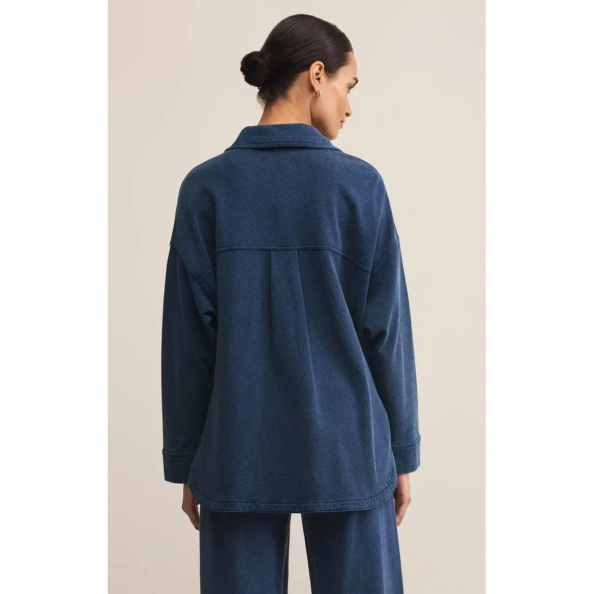 Z Supply All Day Knit Denim Jacket in blue, back view on model with relaxed fit and curved hem.