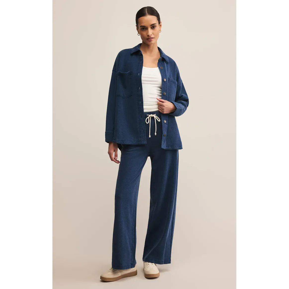 Model wearing Z Supply All Day Knit Denim Jacket in indigo with matching knit denim pants and white top.