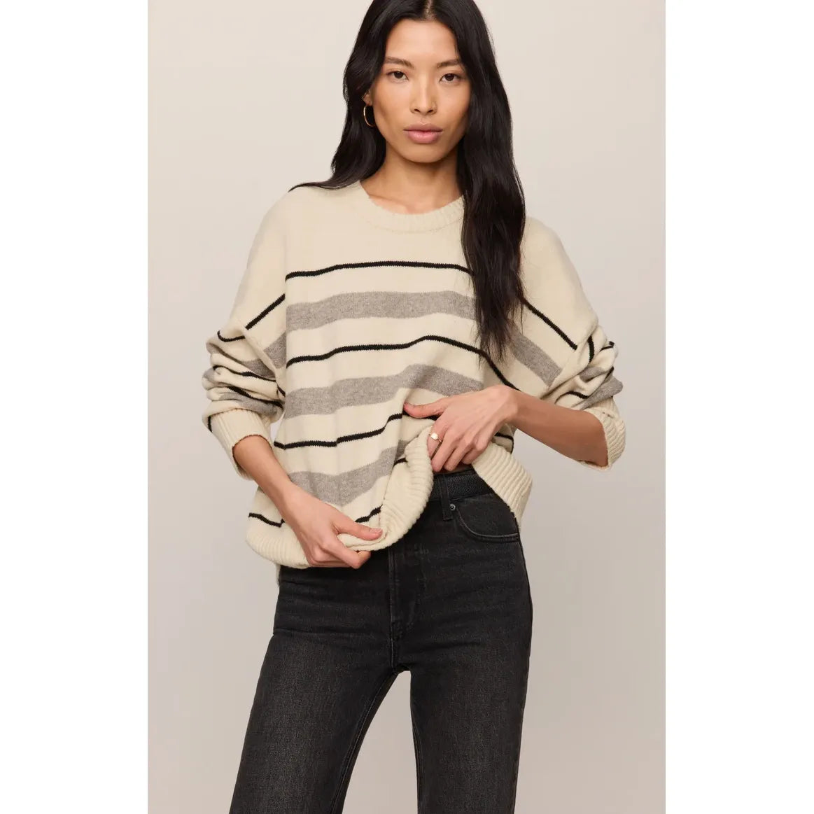Relaxed fit cream sweater with grey and black horizontal stripes, ultra-soft lightweight knit paired with dark jeans.