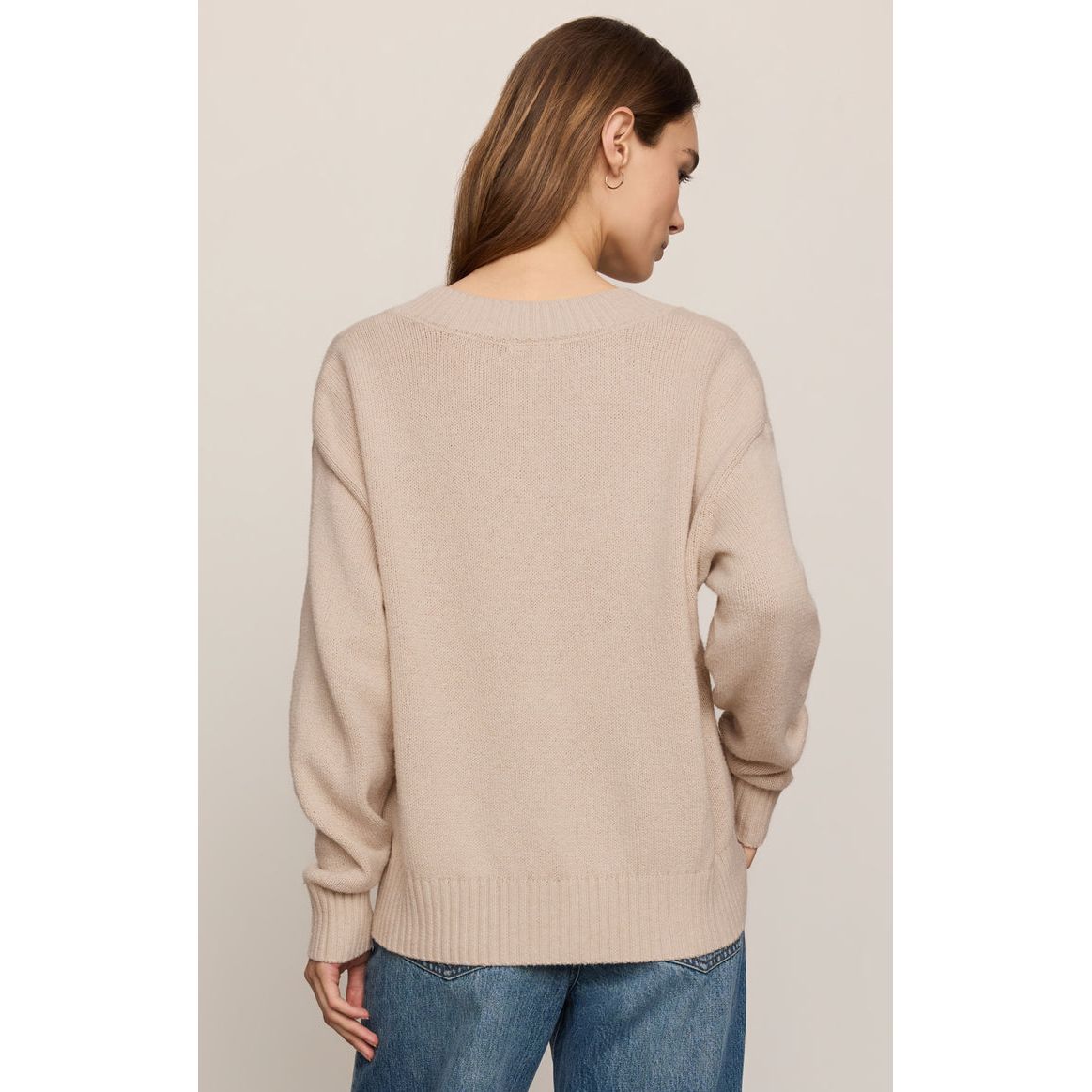 Back view of a woman wearing a frosted pearl Z Supply Cloud Spun V-neck sweater with relaxed fit and ribbed hem.