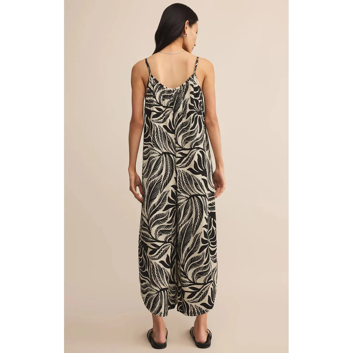 Z Supply Flared Palm Jumpsuit back view: model wearing black-and-cream tropical palm gauze wide-leg jumpsuit