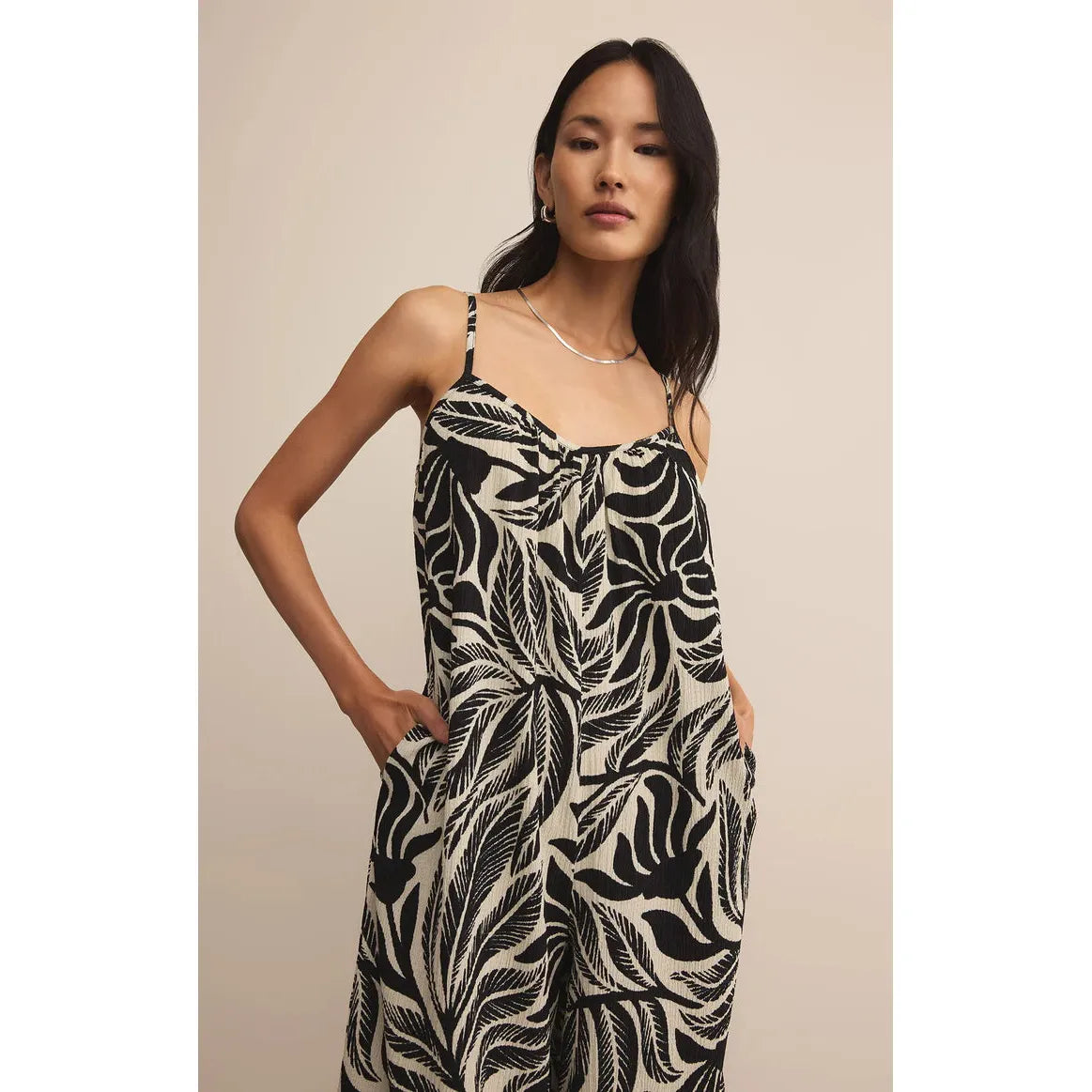 Z Supply Flared Palm Jumpsuit in black cream gauze with tropical palm print, wide-leg silhouette and spaghetti straps.