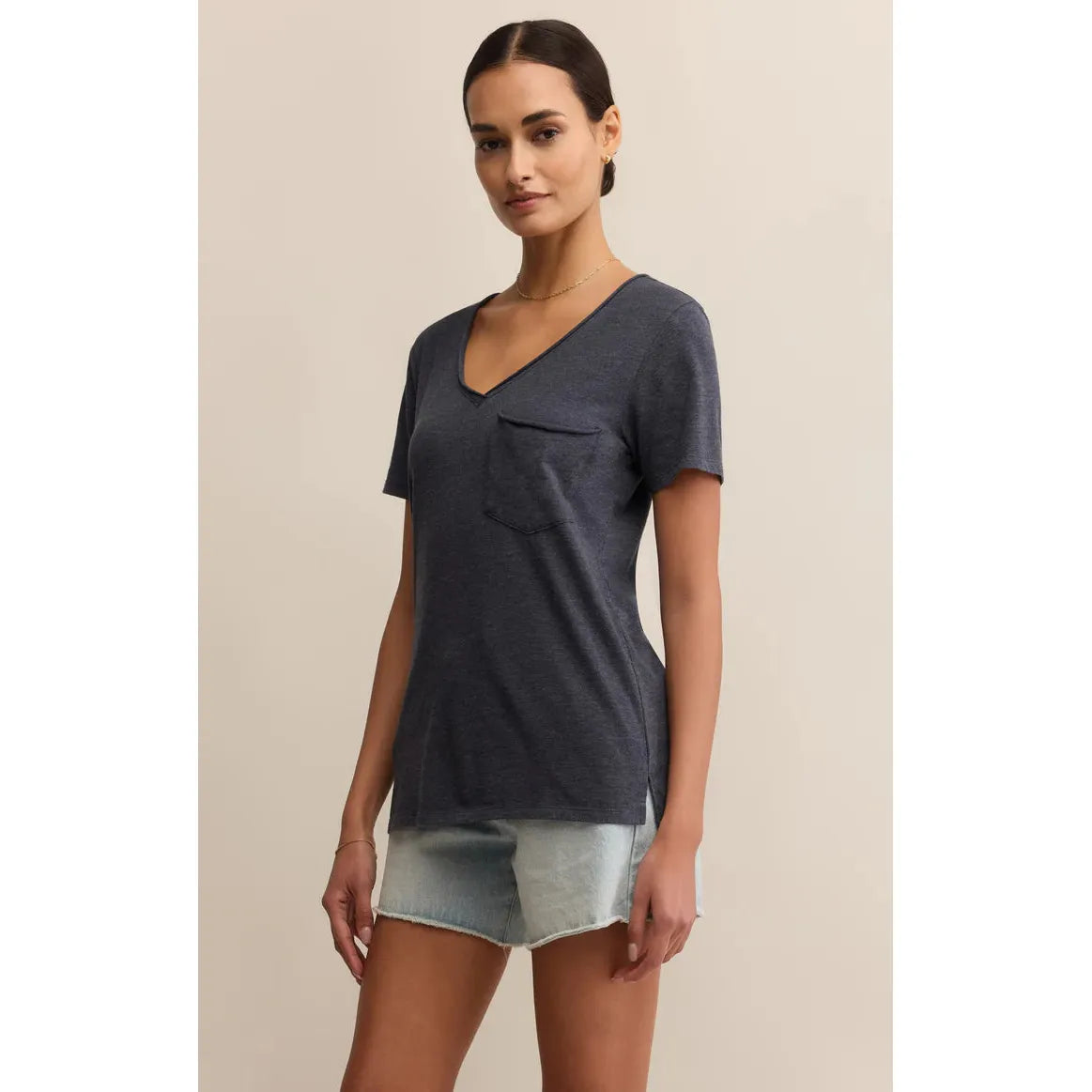 Model wearing Z Supply Modern Pocket Tee in charcoal with v-neck, raw-edge pocket and straight hem and denim shorts