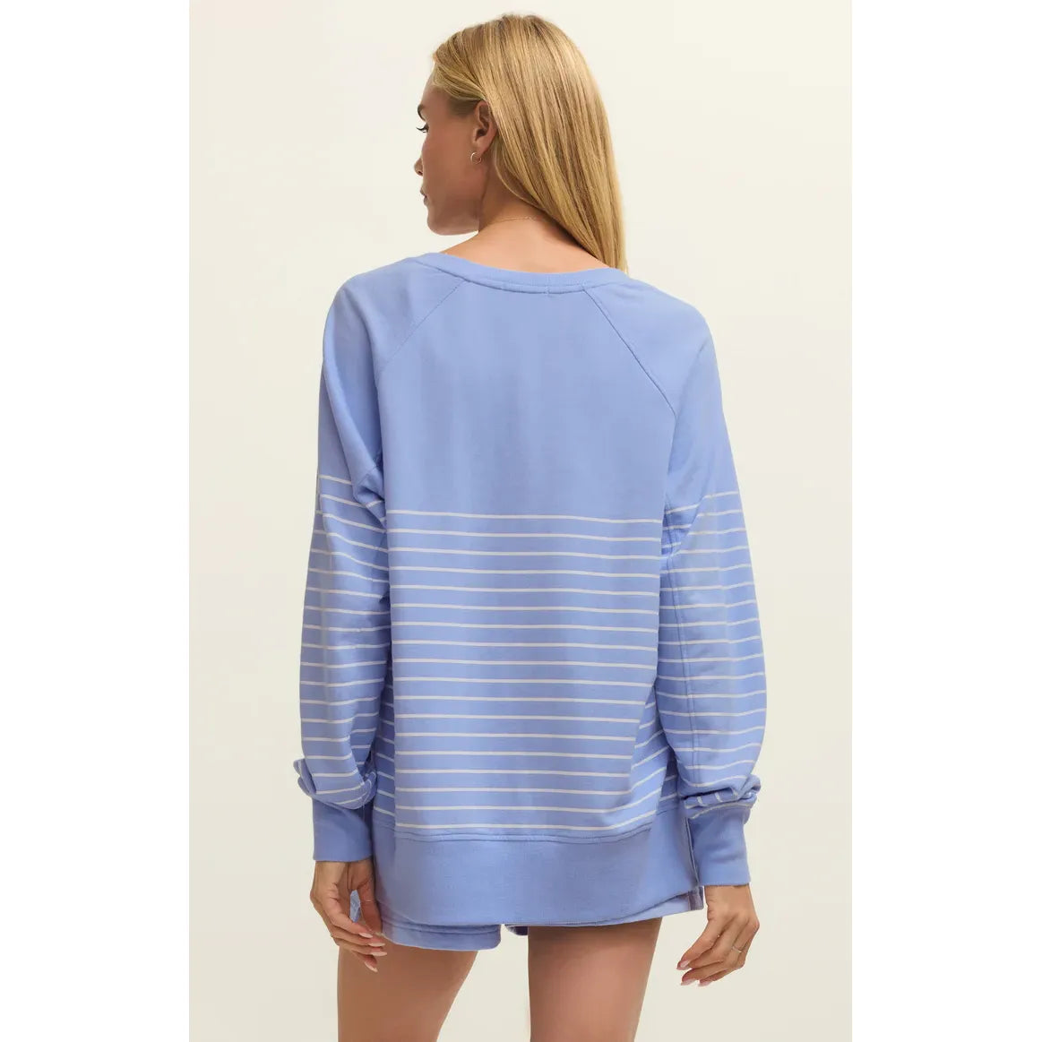 Back view of model wearing blue striped Z Supply Weekender V-Neck Sweatshirt, relaxed fit with white stripes.