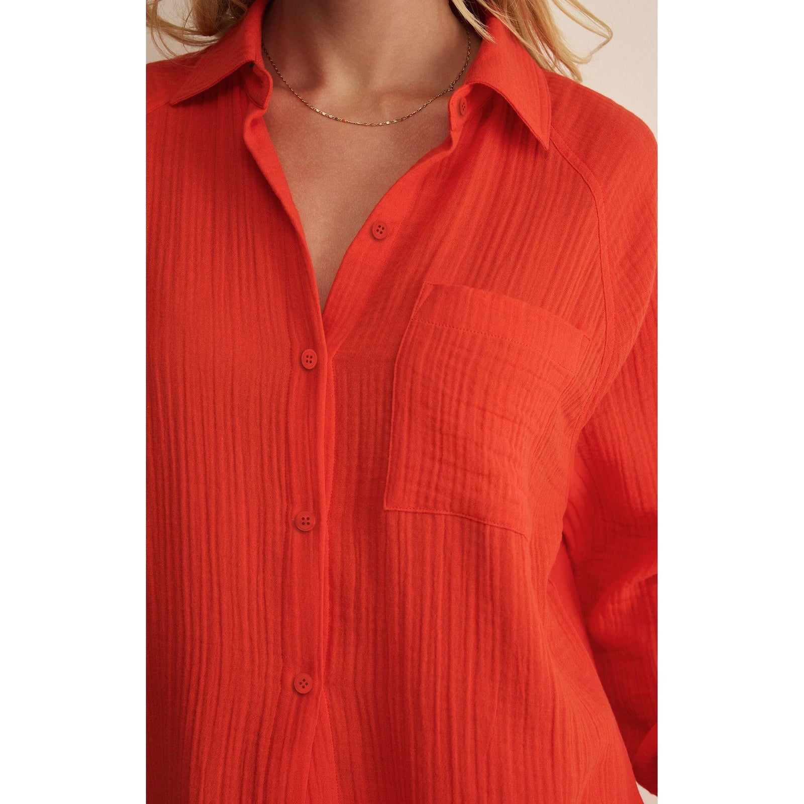 Bright coral red airy gauze button-down top with crinkle texture, collar, front buttons, and chest pocket.