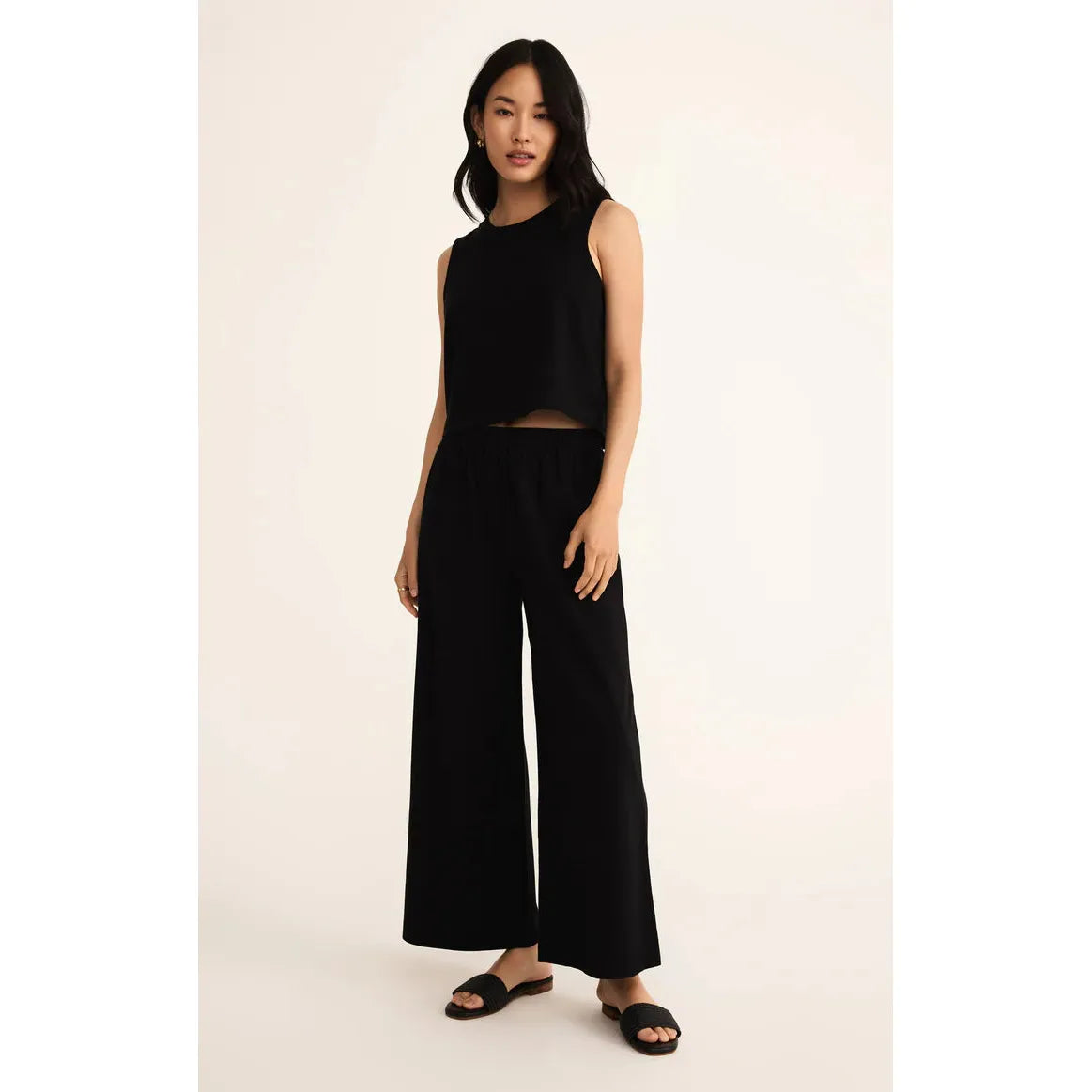 Model wearing black Z Supply Scout Jersey Flare Pant with a matching sleeveless crop top.