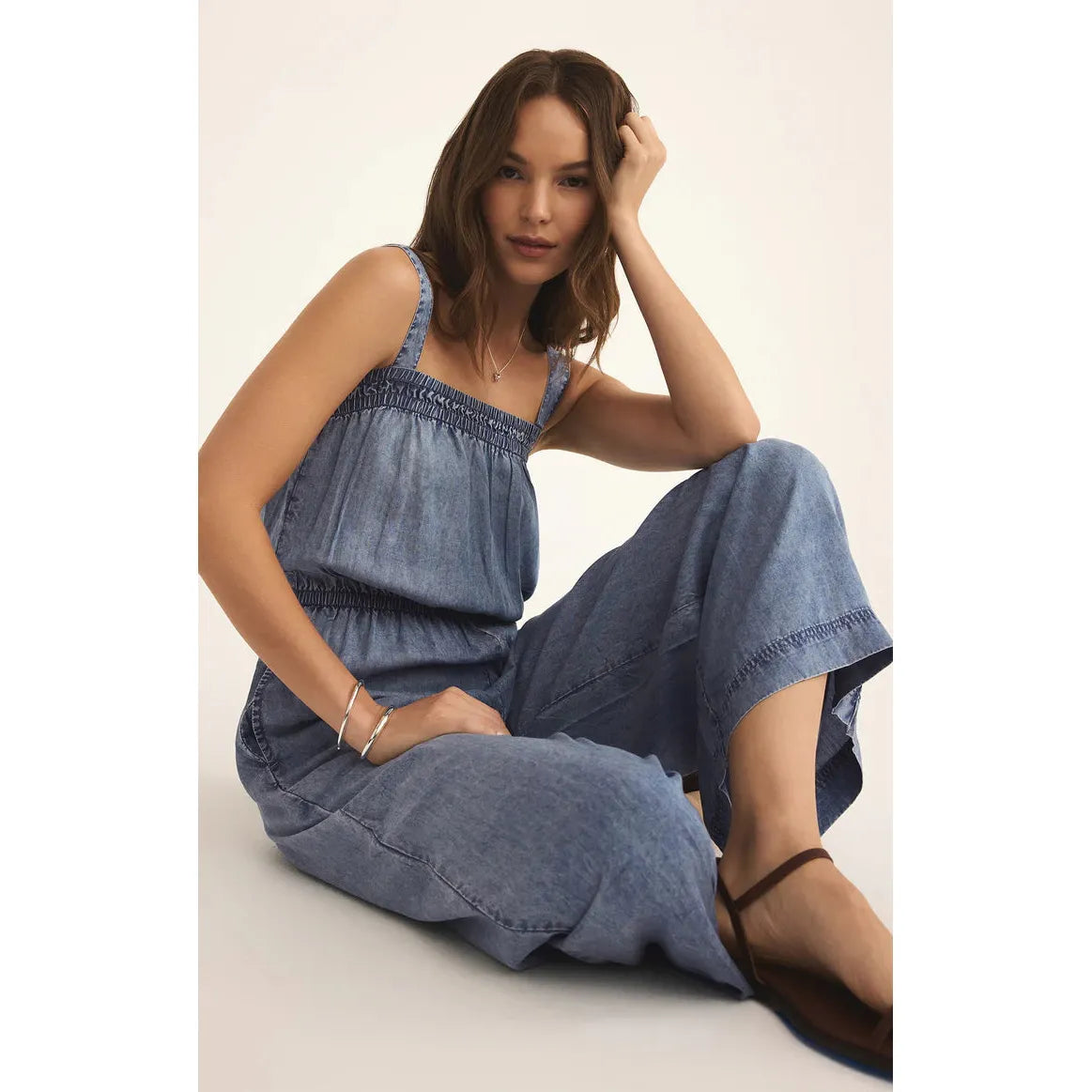 Z Supply Solara Chambray Jumpsuit features cozy washed chambray, adjustable straps, and a stylish square neckline.