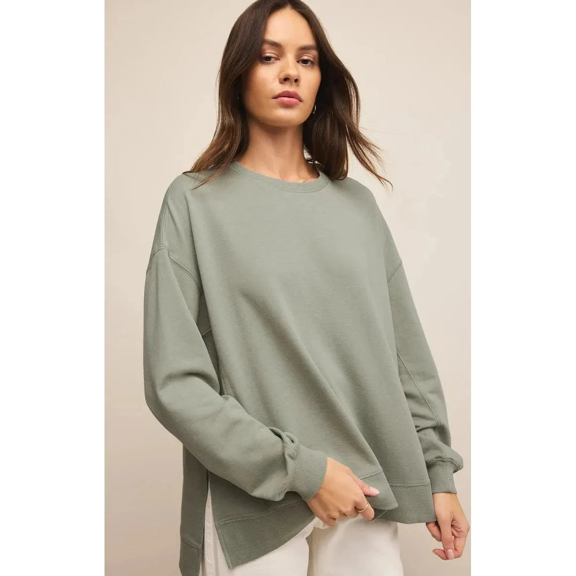 Stylish model wearing the Z Supply Modern Weekender in sage green, showcasing its oversized fit and cozy design.