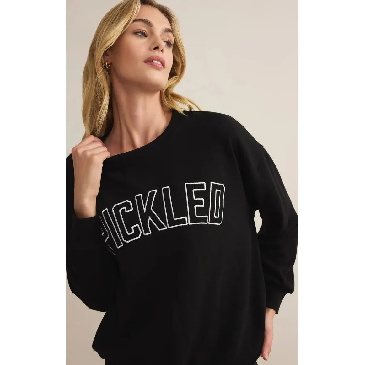 Stylish model showcasing the Z Supply Pickled Sweat Shirt with "Pickled" embroidery, perfect for casual wear.