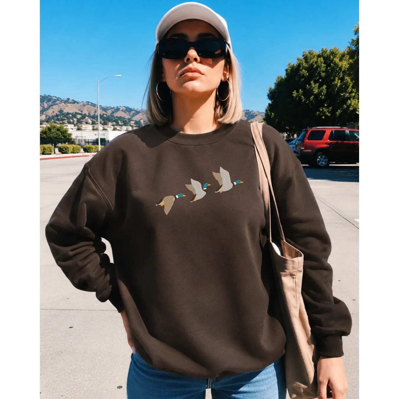 Brown crew neck sweater featuring three flying mallard duck graphic on chest