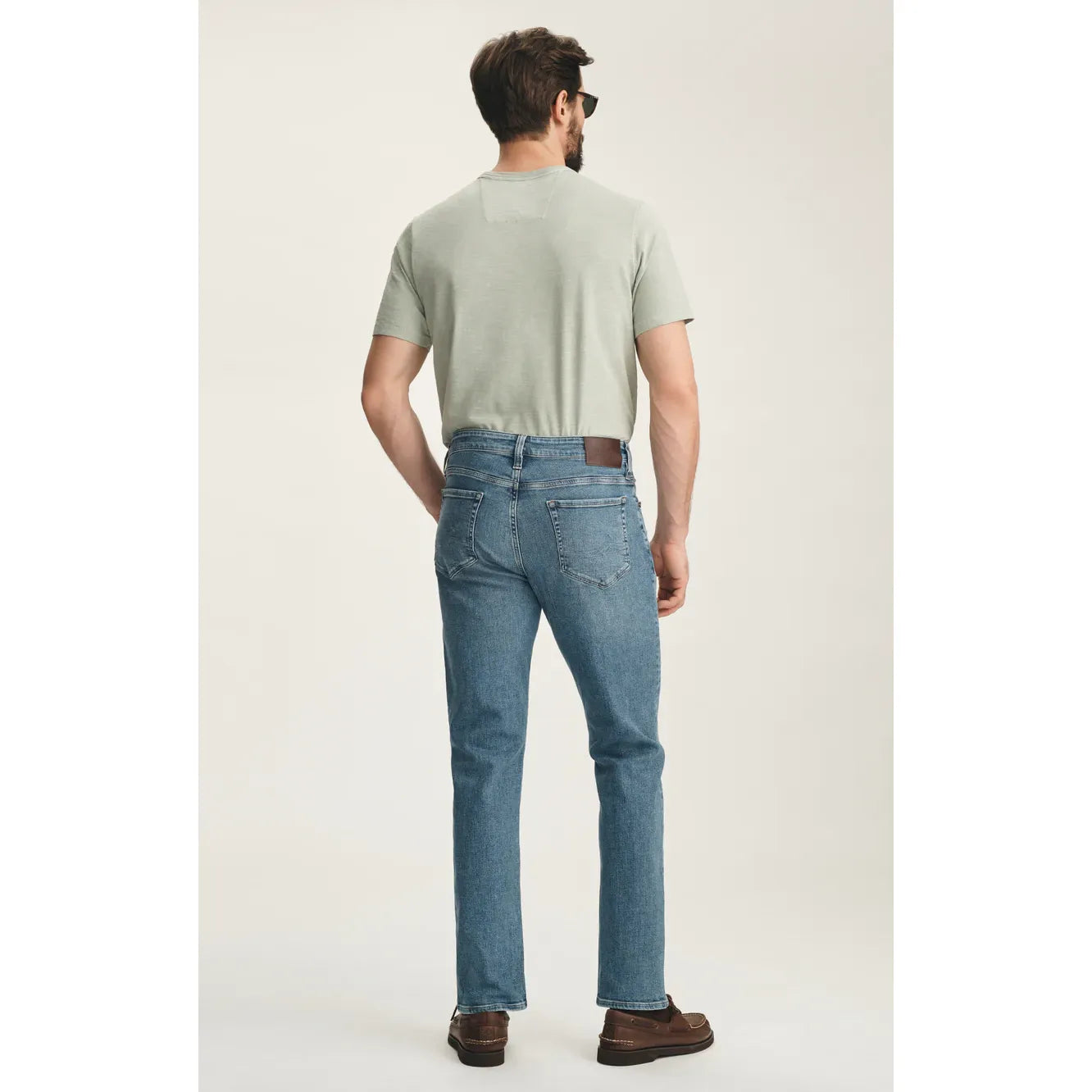 Model wearing 34 Heritage Camino in Lt Brushed Vintage straight-leg jeans in light blue wash with subtle fading, mid-rise.