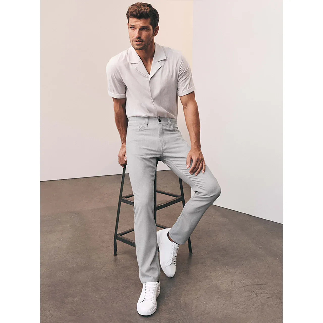 34 Heritage Courage in Bone Cross Twill pants on a male model wearing a pale shirt and white sneakers.