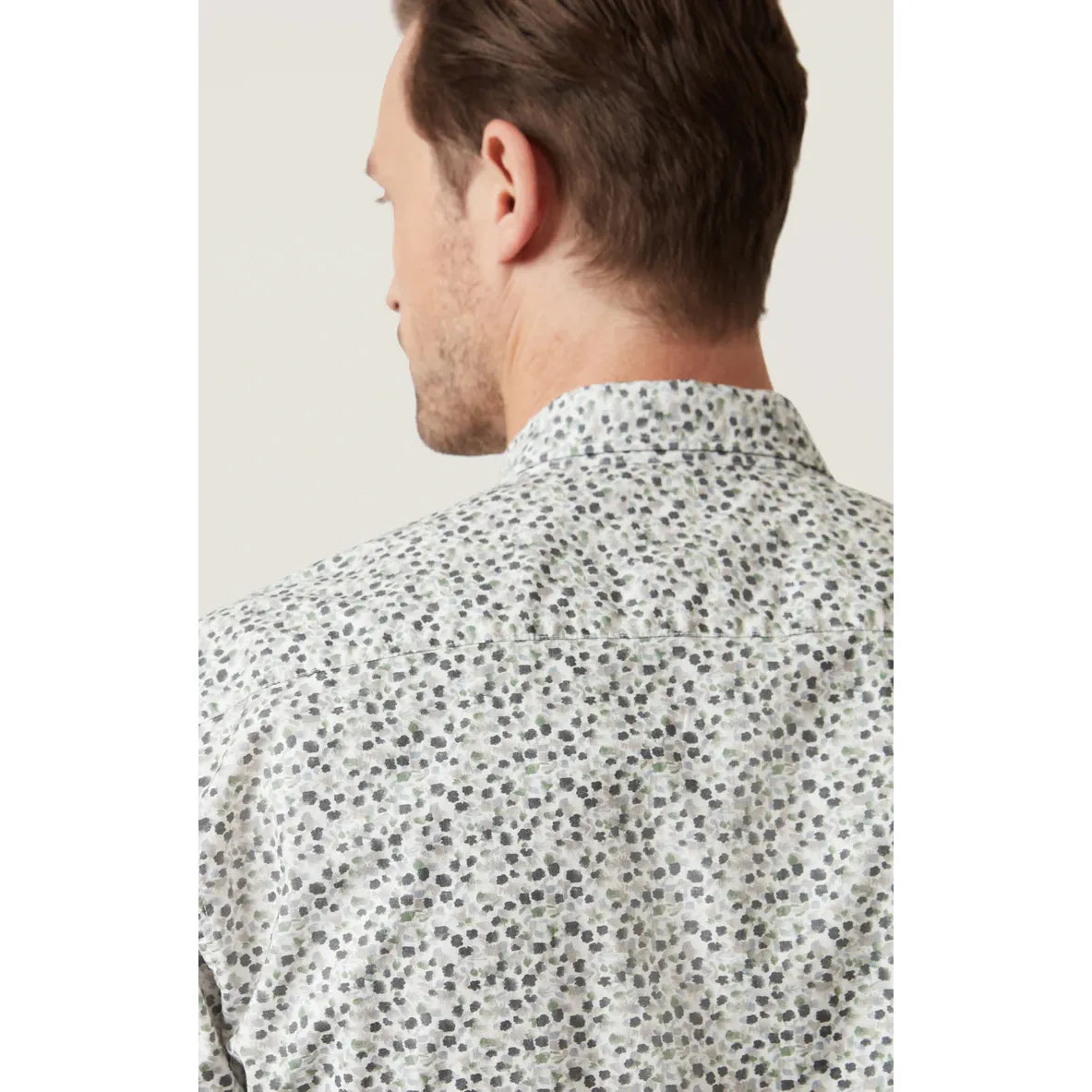 Back view of a man wearing the 34 Heritage Grove Short Sleeve Shirt with a white floral print.