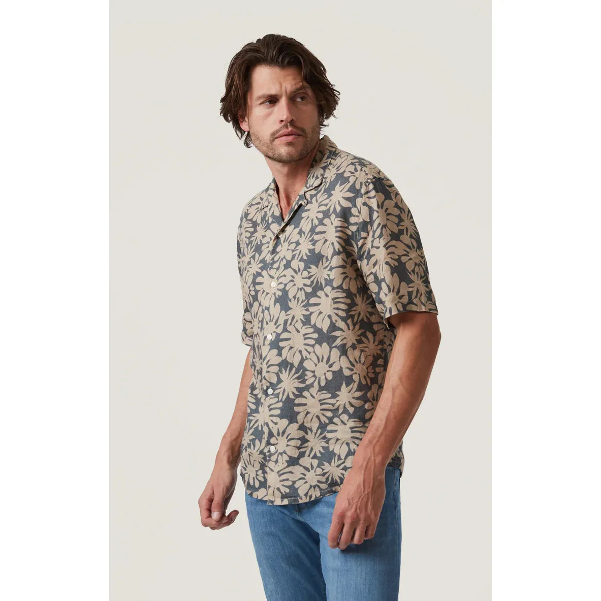 Male model wearing 34 Heritage Bloom Short Sleeve Shirt in blue-gray linen with beige floral print.