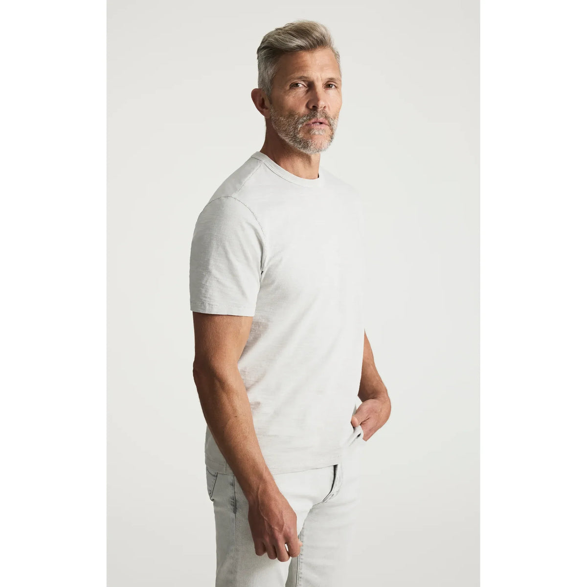 Male model wearing a light gray 34 Heritage Slub Crew Tshirt in profile pose.