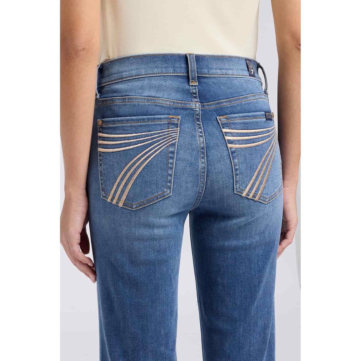 7 For All Mankind Dojo jeans in Gale with mid-rise flare and gold curved embroidery on back pockets.