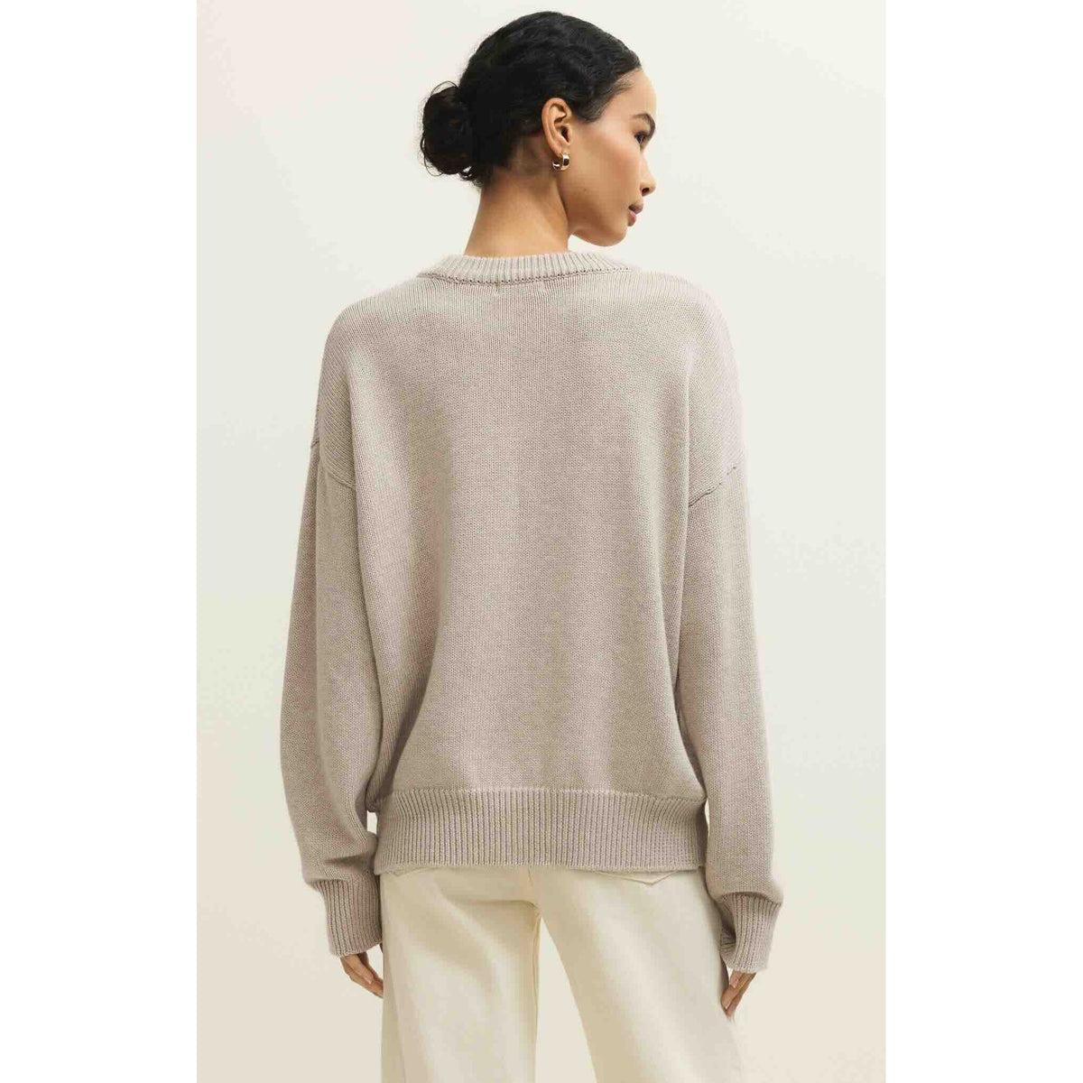 Back view of a model wearing beige Z Supply Boyfriend Beach Sweater, mid-weight knit with ribbed cuffs, 100% cotton.