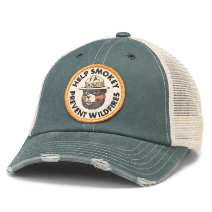 Distressed green trucker hat with cream mesh back featuring circular Smokey Bear patch reading Help Smokey Prevent Wildfires.