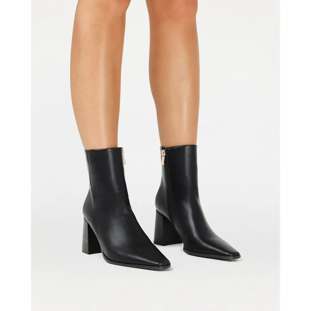 Black Billini Ozi Boot with a closed square toe, mid-flare block heel, and gold zip detail on the side.