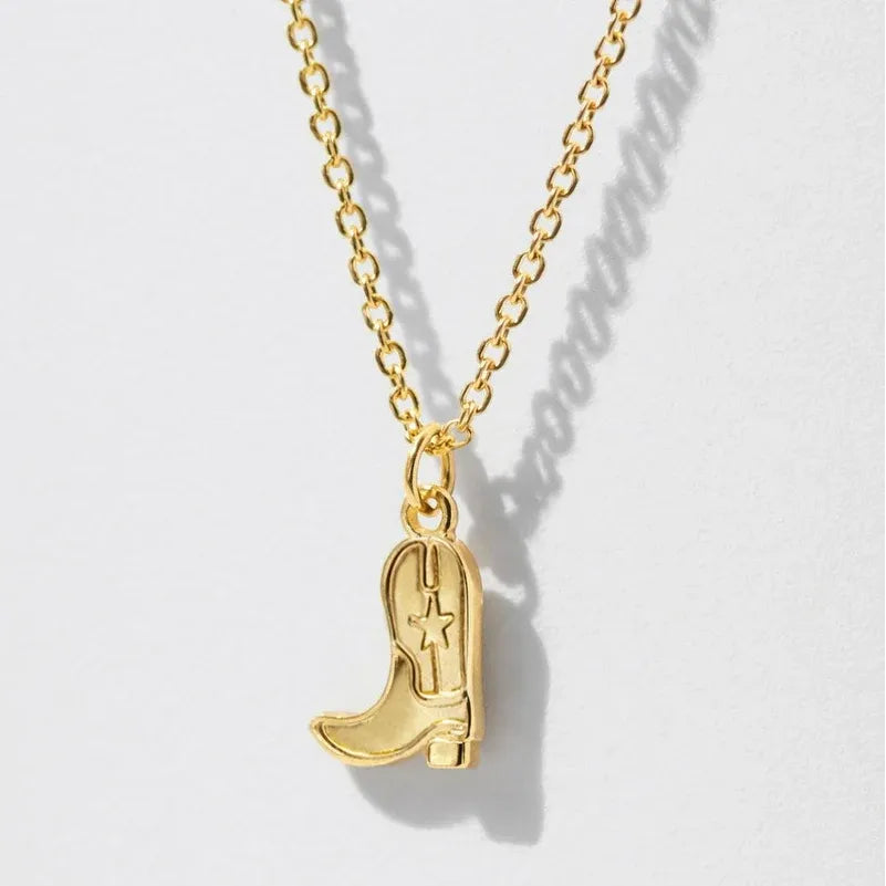 Gold chain necklace featuring a sculpted cowgirl boot pendant with a star detail, adding playful western charm to any outfit.