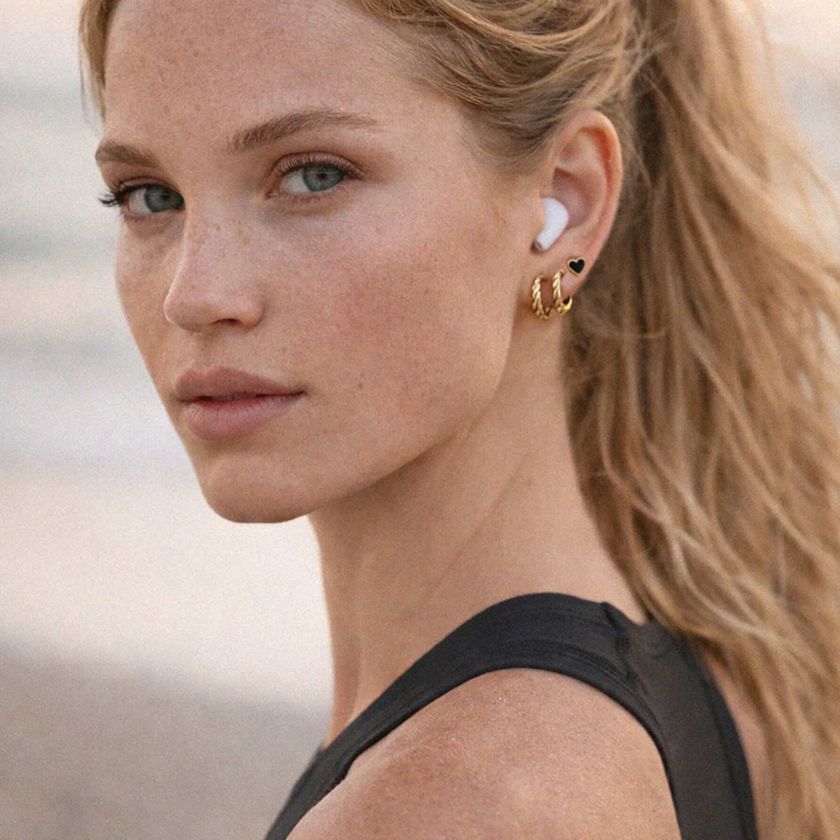 Wavy Gold-Tone Earrings: twisted textured stainless steel hoops catching light.