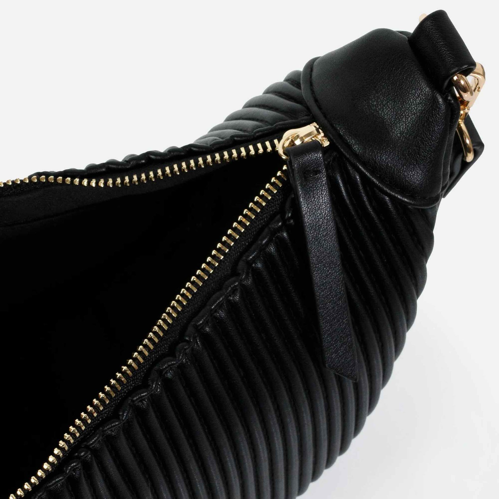 Black crescent moon-shaped crossbody bag with ribbed, wavy PU texture and gold hardware, zipper details.