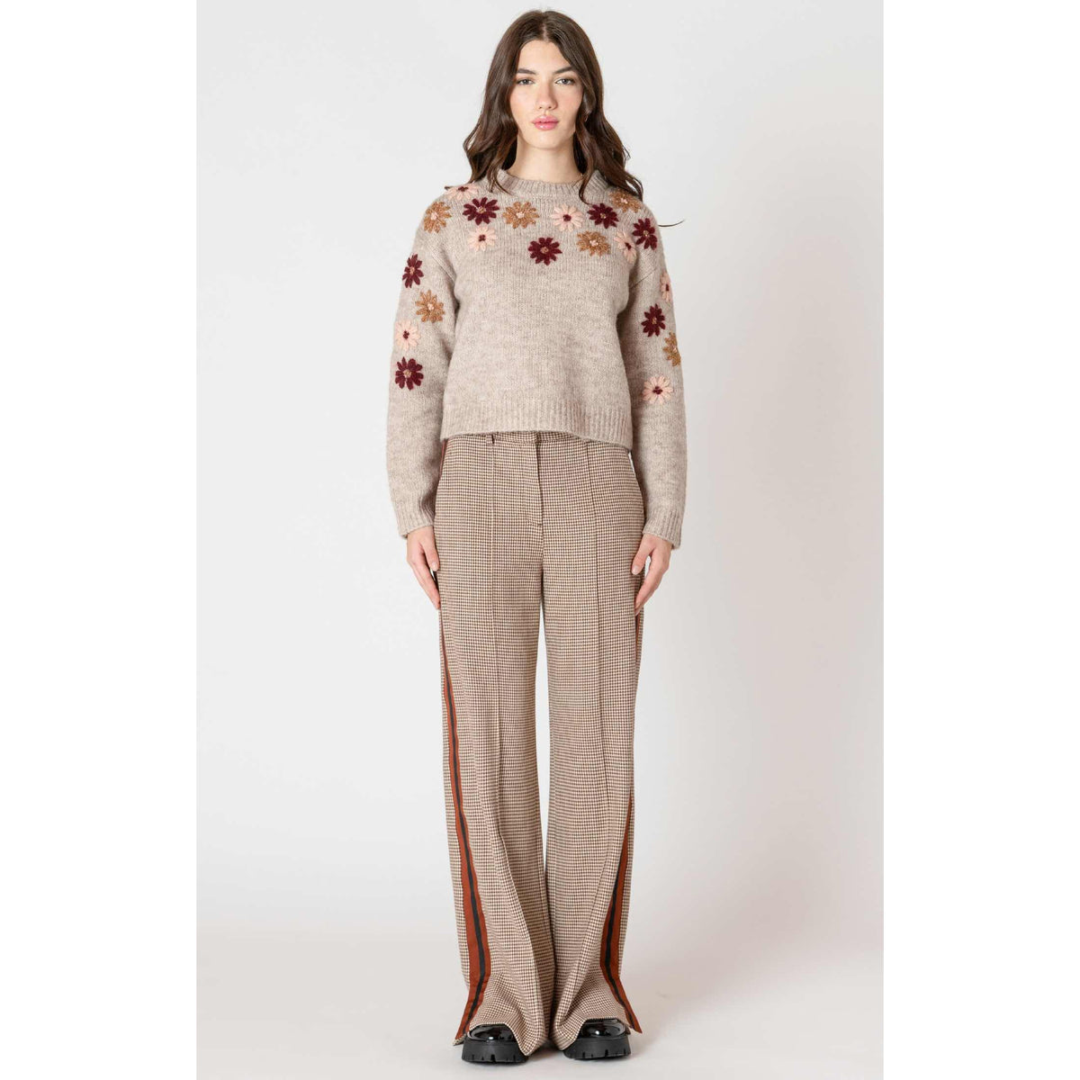 Dex Black Tape Floral Applique Crew Sweater on model with beige knit and floral appliques.